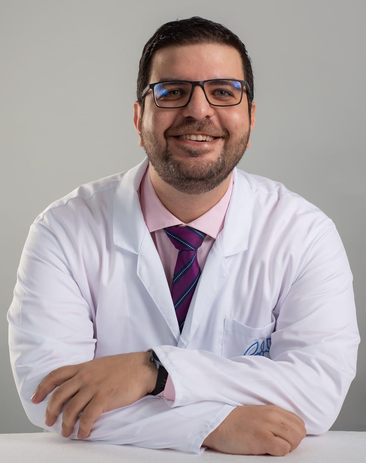 El Dr. Osama Bahsas Zaky sonriendo con bata blanca y los brazos cruzados