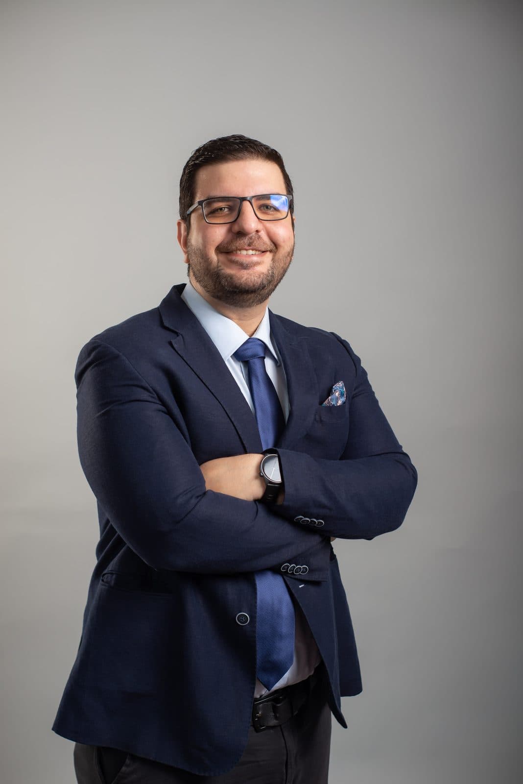 Retrato del Dr. Osama Bahsas Zaky de traje azul y corbata, con los brazos cruzados